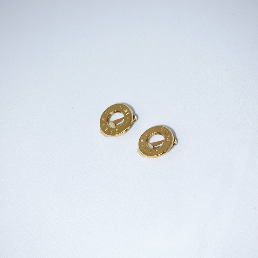 Pair of gold earrings on a light gray background