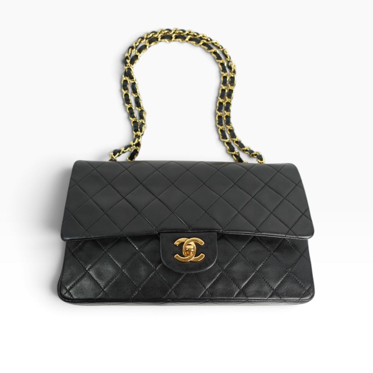 Back view of Chanel Vintage Classic Timeless 25 Double Flap in black quilted lambskin leather, featuring signature diamond stitching and gold-plated chain strap.