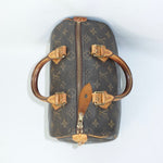 Louis Vuitton monogram handbag with gold hardware on a white background