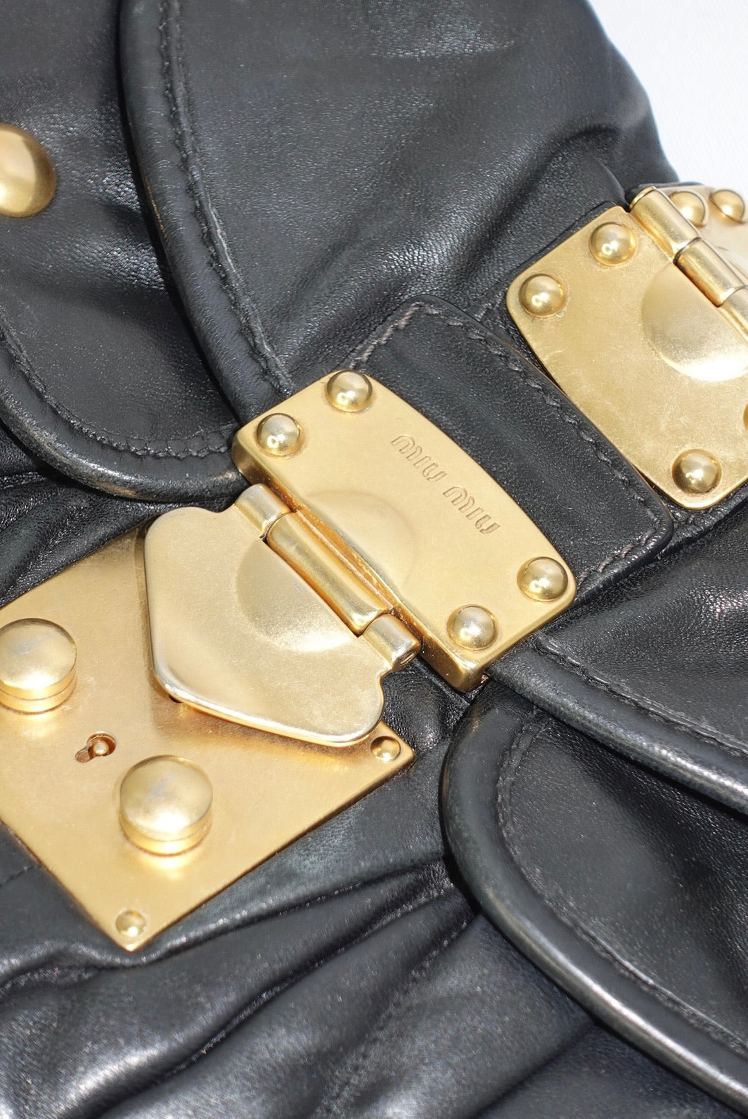 Close-up of Miu Miu black matelassé leather quilting and hardware detail