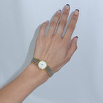    Vintage Omega De Ville two-tone watch with a white dial and gold-tone round case.