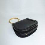 Black handbag with a gold ring on a white background