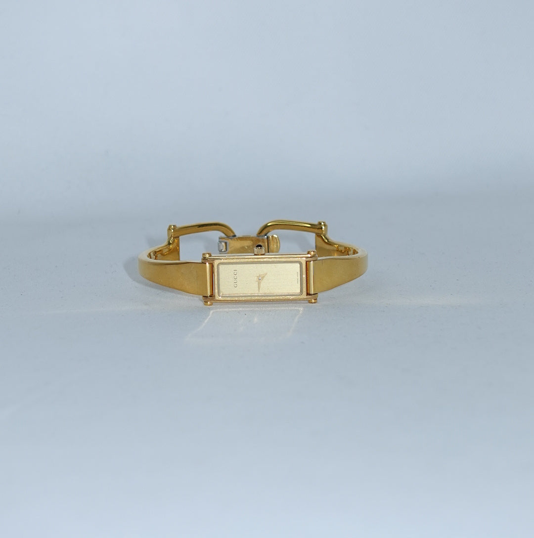 Vintage Gucci 1500L gold-tone watch with a rectangular gold dial