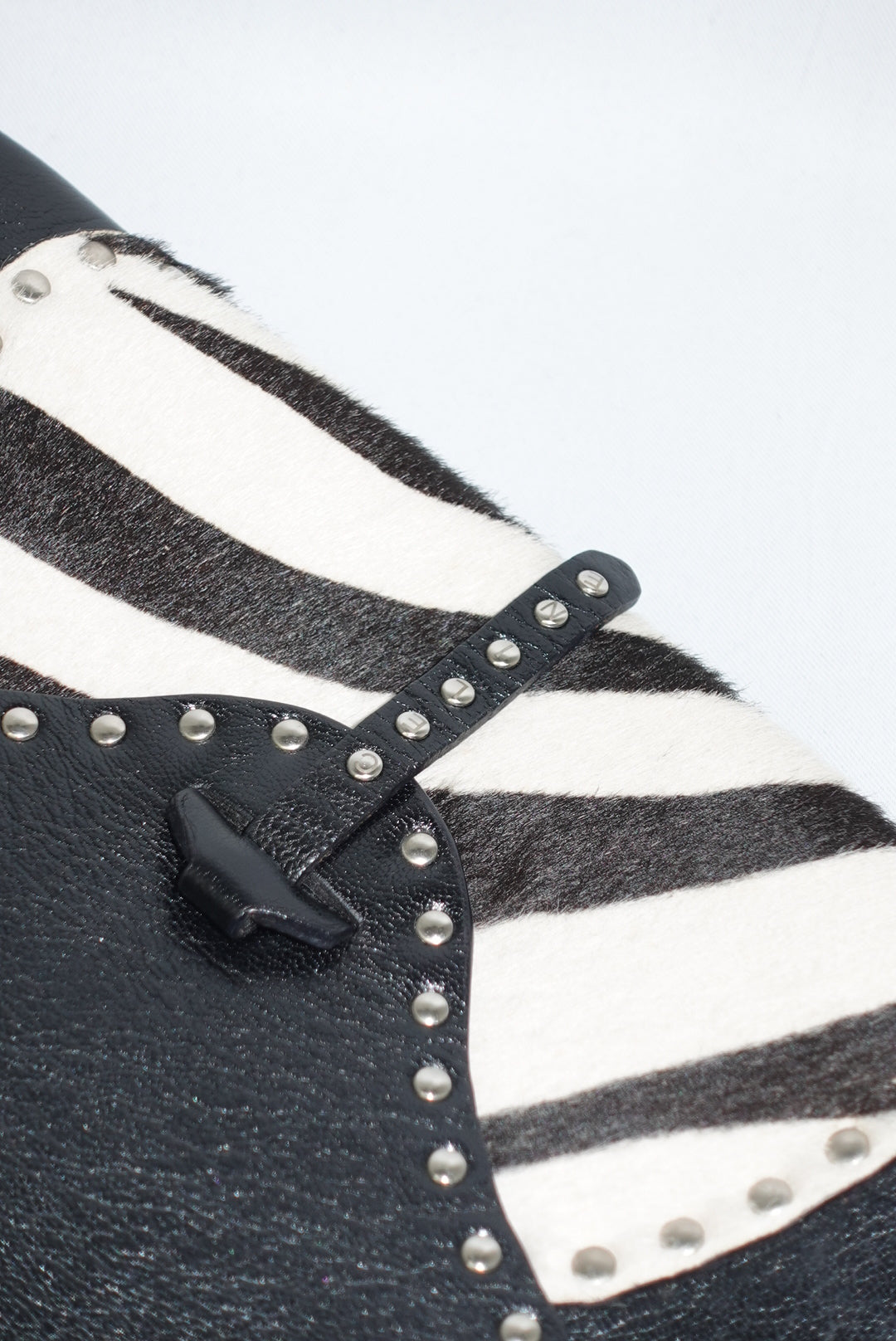 Side angle view of the Celine bag displaying the leather shoulder strap and structured profile. The image highlights the bag’s depth, craftsmanship, and how the zebra pony hair detail wraps seamlessly into the leather construction.