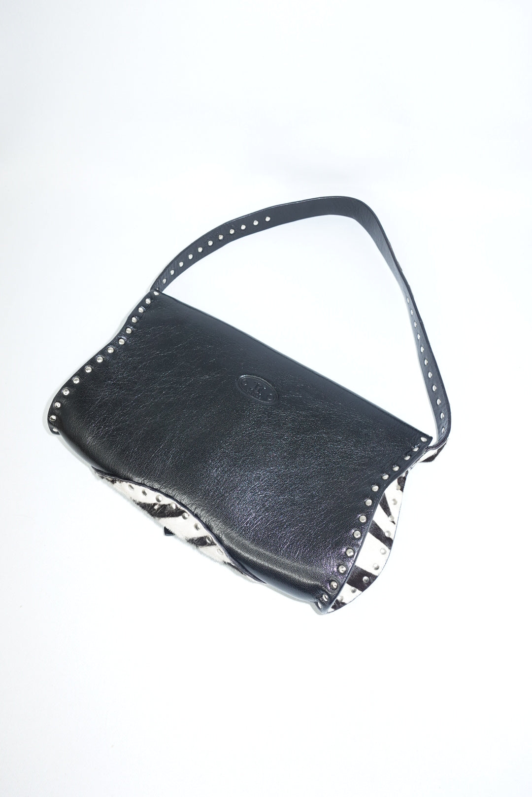 Back angle view of the bag displaying the leather shoulder strap and structured profile. The image highlights the bag’s details and craftsmanship