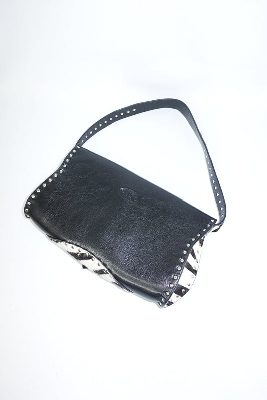 Back angle view of the bag displaying the leather shoulder strap and structured profile. The image highlights the bag’s details and craftsmanship