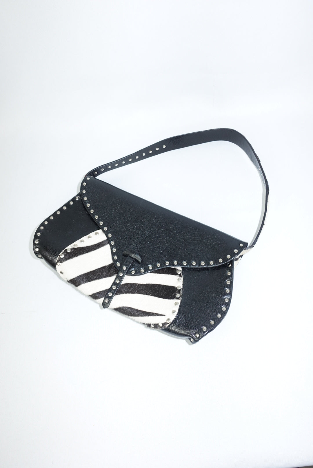 Front view of the Celine vintage shoulder bag showcasing smooth black leather contrasted with a bold zebra pony hair panel. The structured silhouette highlights the bag’s early-2000s design, with clean lines