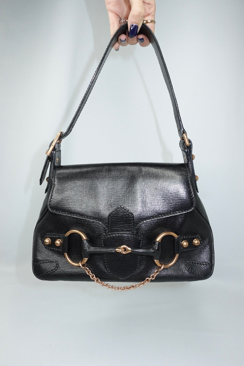 view of the bag displaying the leather shoulder strap and structured silhouette. The image emphasizes the bag’s proportions, craftsmanship, and timeless shoulder-carry design.
