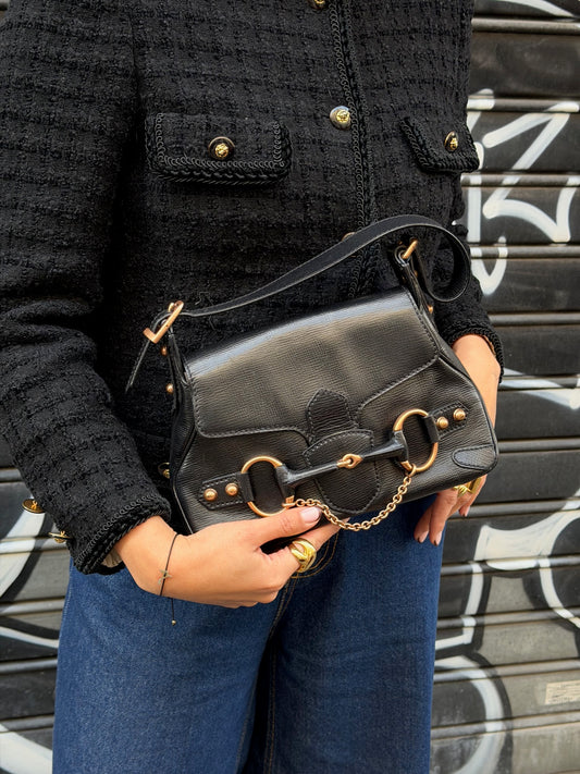 Front view of the vintage Gucci Horsebit shoulder bag featuring  black leather and the signature bronze-toned horsebit hardware centered on the flap. The image highlights the bag’s clean lines and classic Gucci aesthetic.