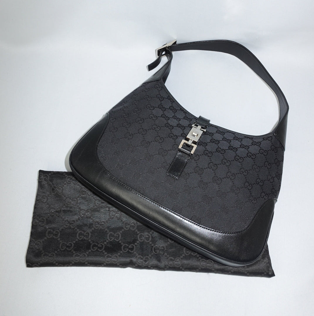 Gucci Vintage Jackie black shoulder bag in GG monogram canvas with silver hardware and leather trim, hobo style silhouette