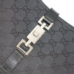 Close-up detail of Gucci Jackie bag silver hardware and black GG canvas pattern with leather edging
