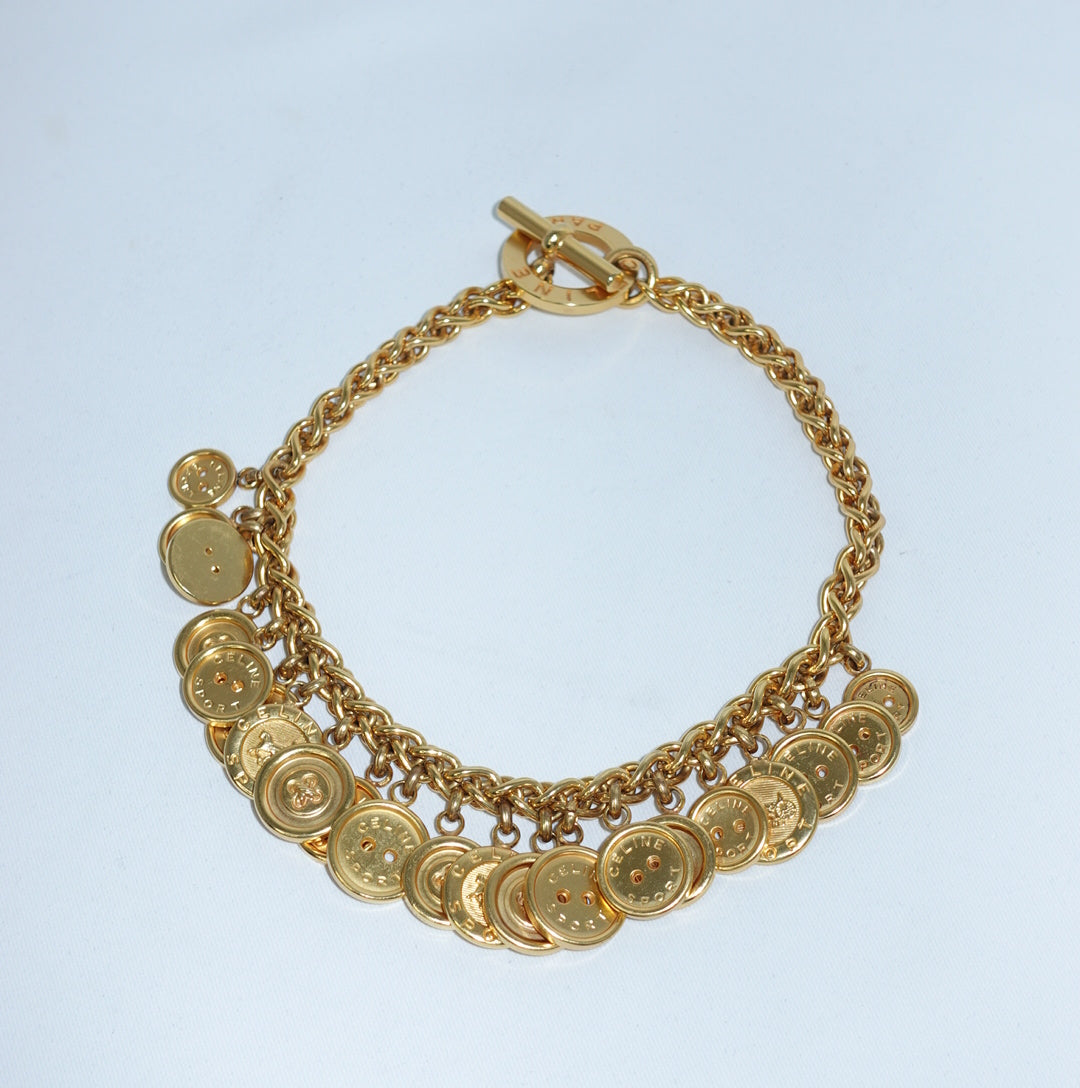 Vintage Celine gold-plated button charm necklace still life featuring chunky chain and signature medallion charms