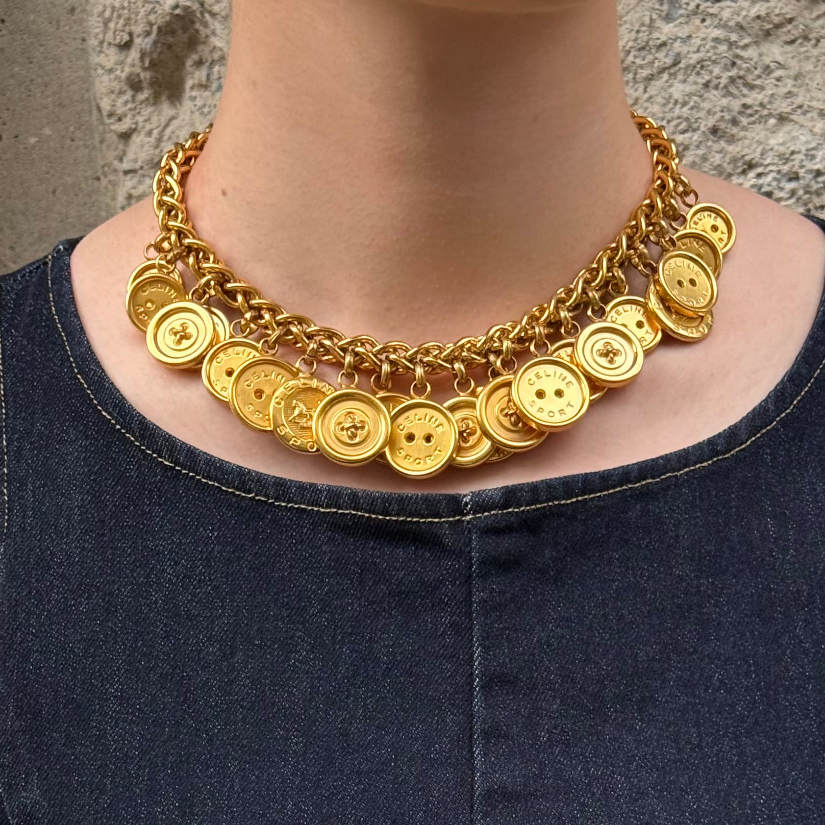 Vintage Celine gold-plated button charm necklace worn by model with chunky chain and signature medallion details