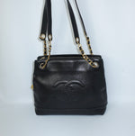 Chanel Black Caviar Leather Tote Bag  front view with oversized CC logo and gold chain straps