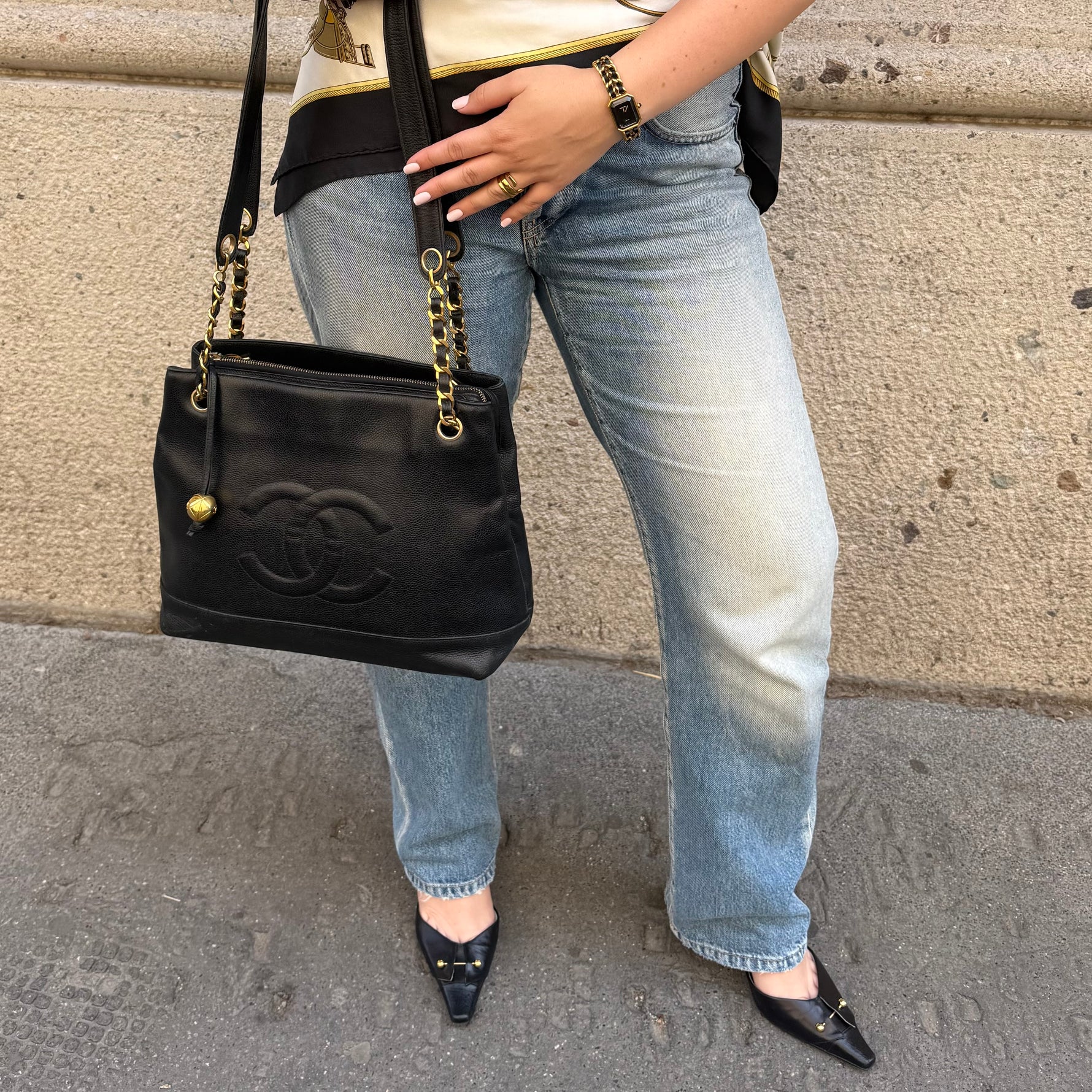 Chanel Black Caviar Tote Bag worn side view with oversized CC logo and gold chain straps