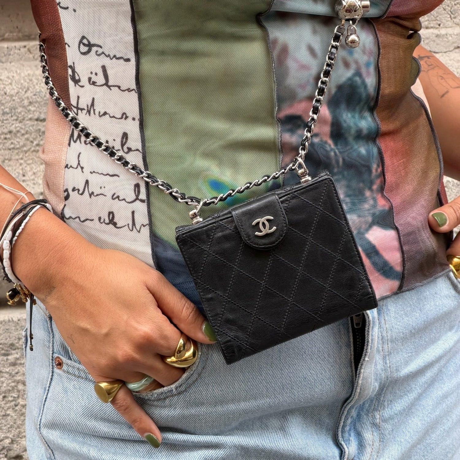 Model wearing Chanel black mini wallet reworked with chain as a crossbody bag.