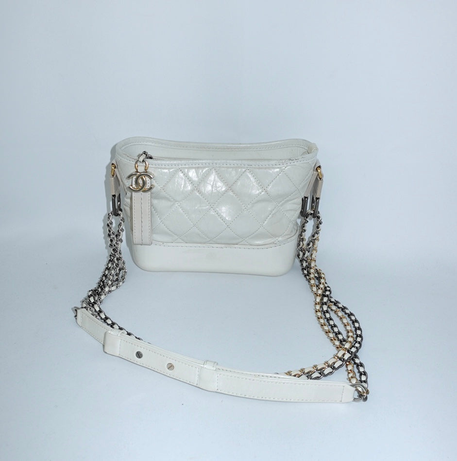 Chanel Gabrielle white leather Hobo Bag still life showing structured base and signature chain detaili