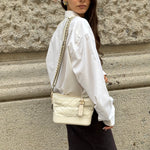 Chanel Gabrielle white leather Hobo Bag worn over the shoulder showing signature chain strap and silhouette