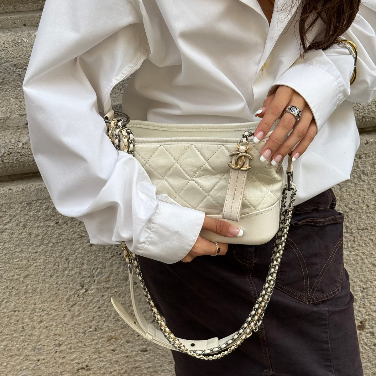 Chanel Gabrielle white leather Hobo Bag worn by model showing size, shape and signature chain detailing