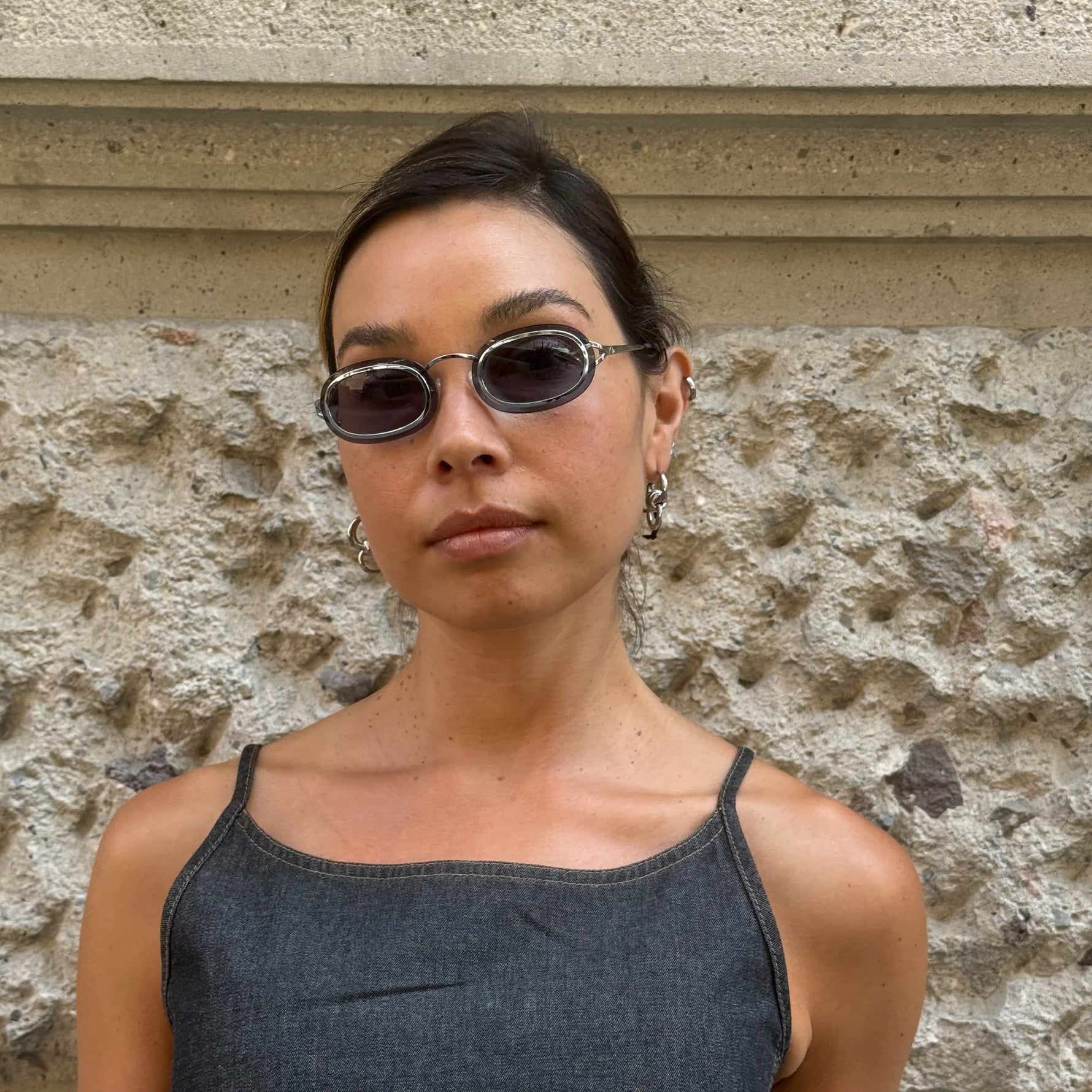 Front view of Christian Dior oval sunglasses with silver-tone metal frame and slim dark tinted lenses.