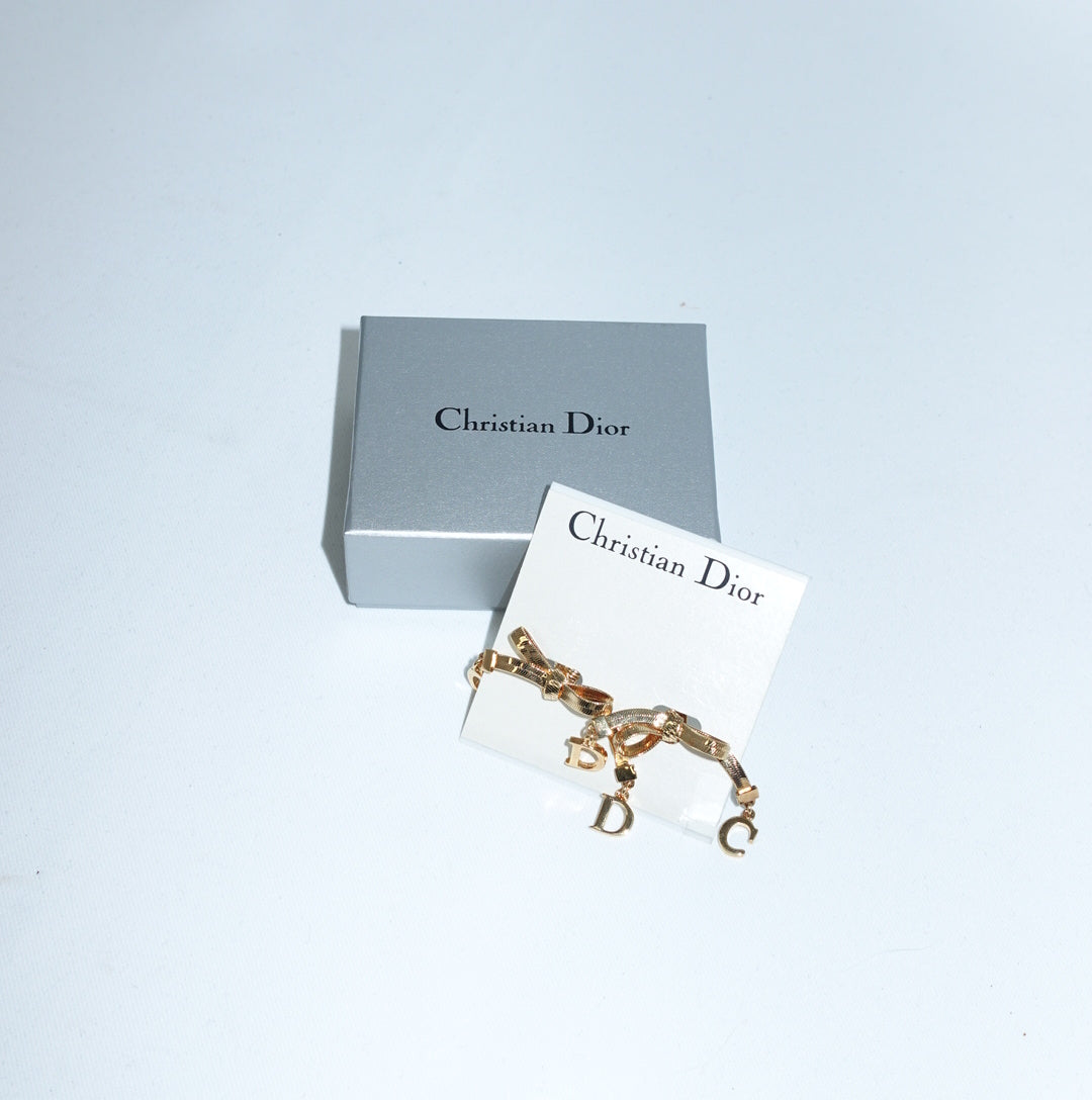Vintage Christian Dior gold-toned ribbon bow earrings with dangling letter charms and original box
