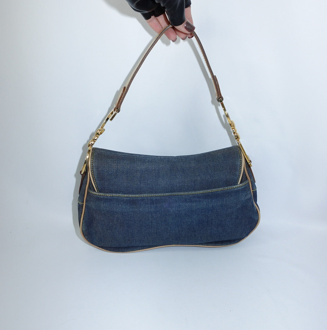 Back view of Dior Denim Double Saddle Bag in blue denim with beige leather trim and gold-tone hardware.