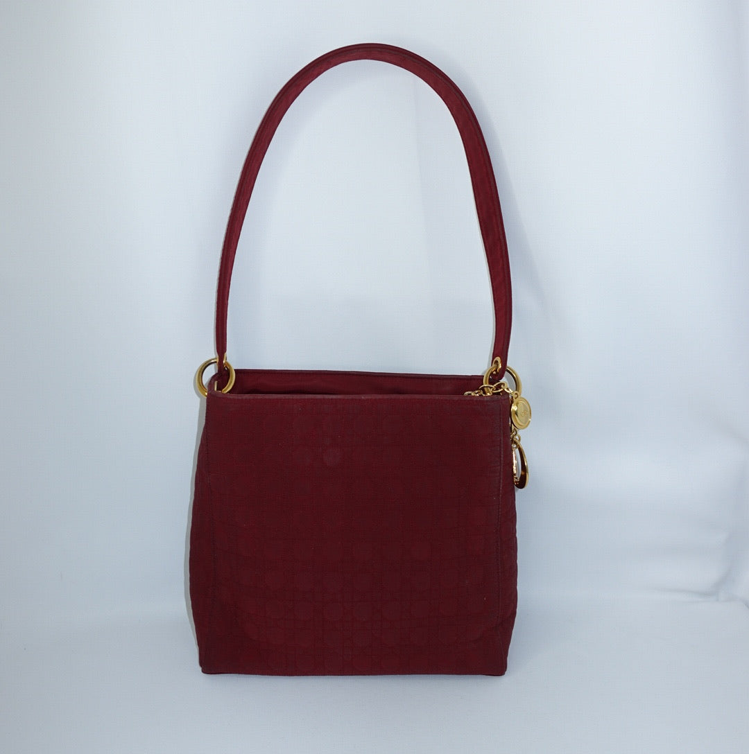 Front view of Dior Lady Dior Cannage red leather bag with gold-tone D.I.O.R. charms.