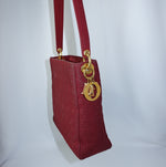 Side view of Dior Lady Dior Cannage red leather bag showcasing its structured silhouette and gold hardware.