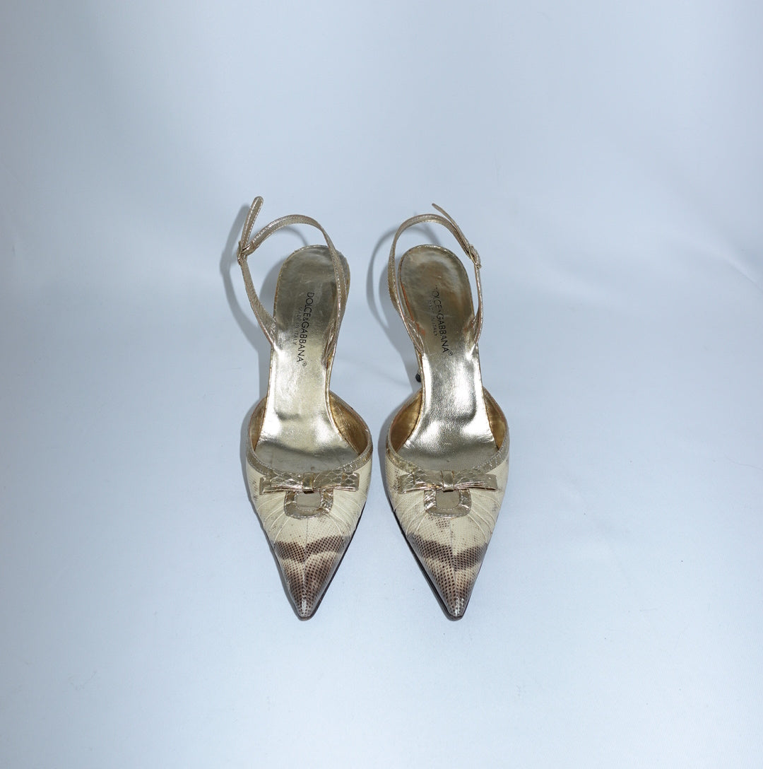 Front view of Dolce & Gabbana Gold Python Heels with pointed toe, metallic gold trim and bow detail.