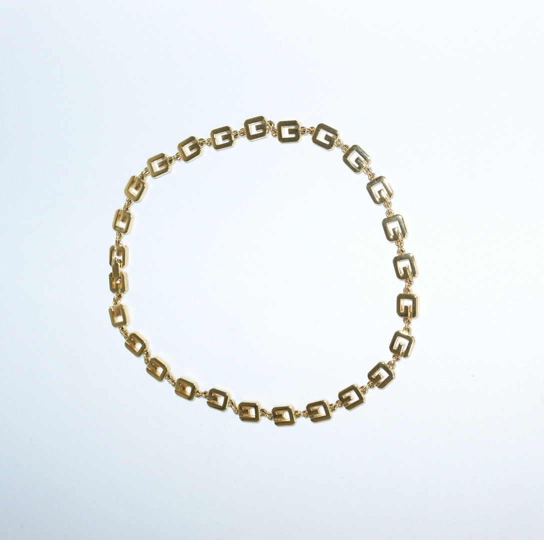 Vintage Givenchy gold-toned geometric logo link necklace still life showing polished chain design