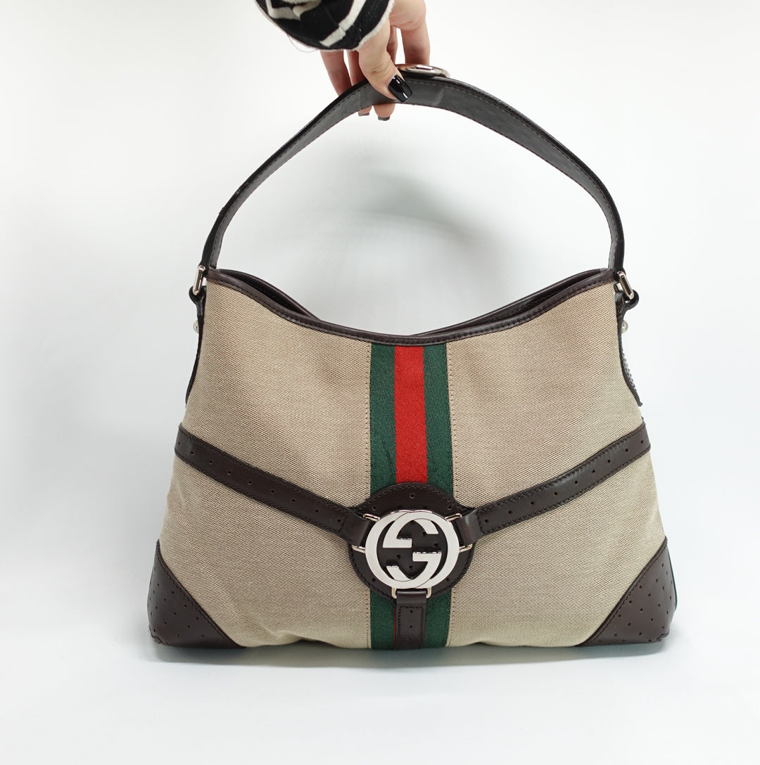 Gucci beige Reins Hobo Bag in GG canvas and brown leather, styled in a still life product photograph