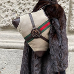 Gucci beige Reins Hobo Bag worn over the shoulder, featuring beige GG canvas, brown leather details, and signature hardware