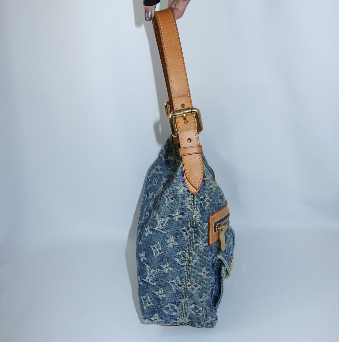 Side view of a Louis Vuitton Denim Baggy Monogram bag showcasing its relaxed hobo silhouette, adjustable leather strap, and exterior flap pockets.