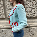 Side view of Moschino Cheap and Chic light blue cropped blazer showcasing its tailored silhouette and signature red trim.