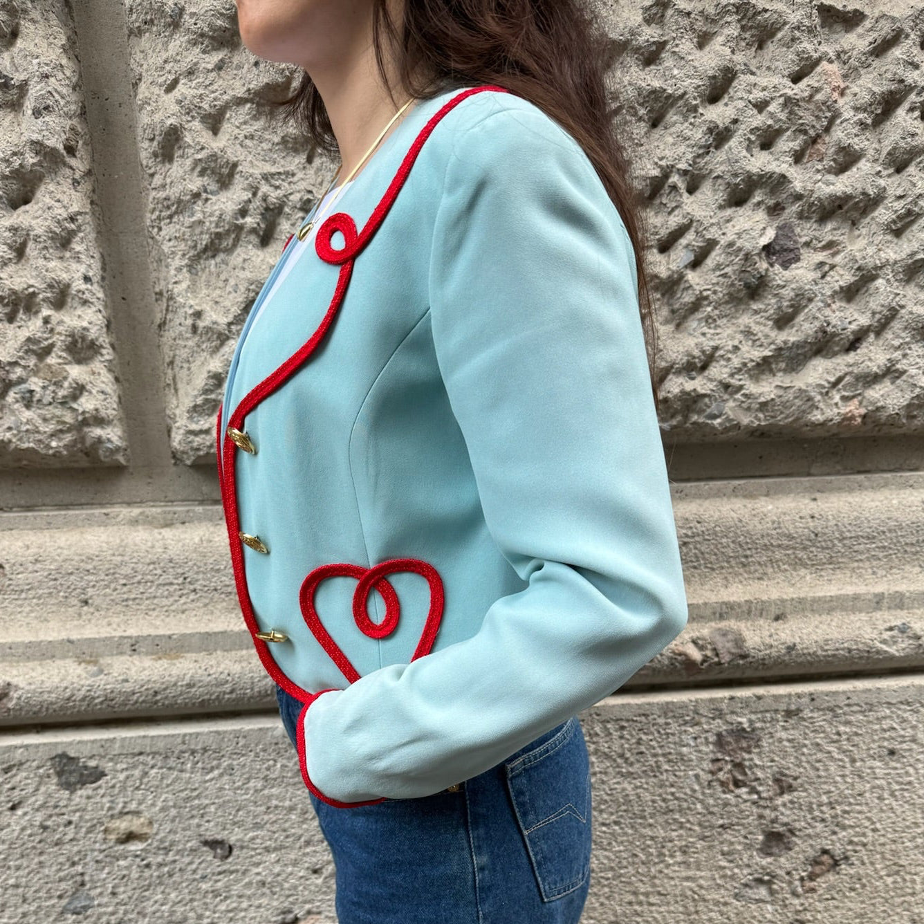 Side view of Moschino Cheap and Chic light blue cropped blazer showcasing its tailored silhouette and signature red trim.