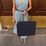 Salvatore Ferragamo navy fabric tote bag with layered ruffles and gold-tone chain handles held by a model.