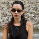 Front view of Prada tortoiseshell cat-eye sunglasses with glossy acetate frame and dark tinted lenses.