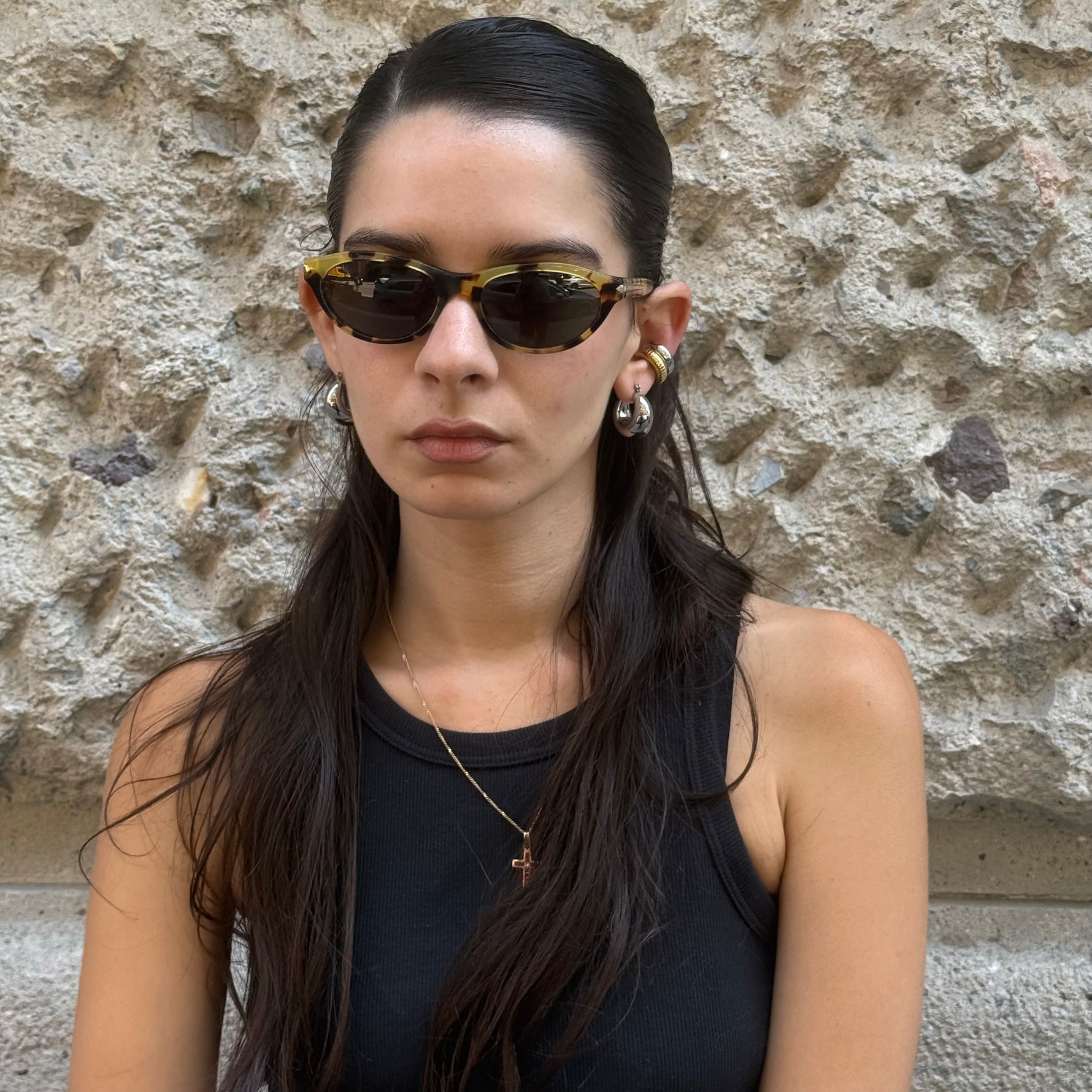 Front view of Prada tortoiseshell cat-eye sunglasses with glossy acetate frame and dark tinted lenses.