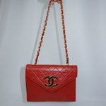 Front view of a vintage Chanel red quilted leather crossbody bag featuring the iconic gold CC logo and chain shoulder strap.