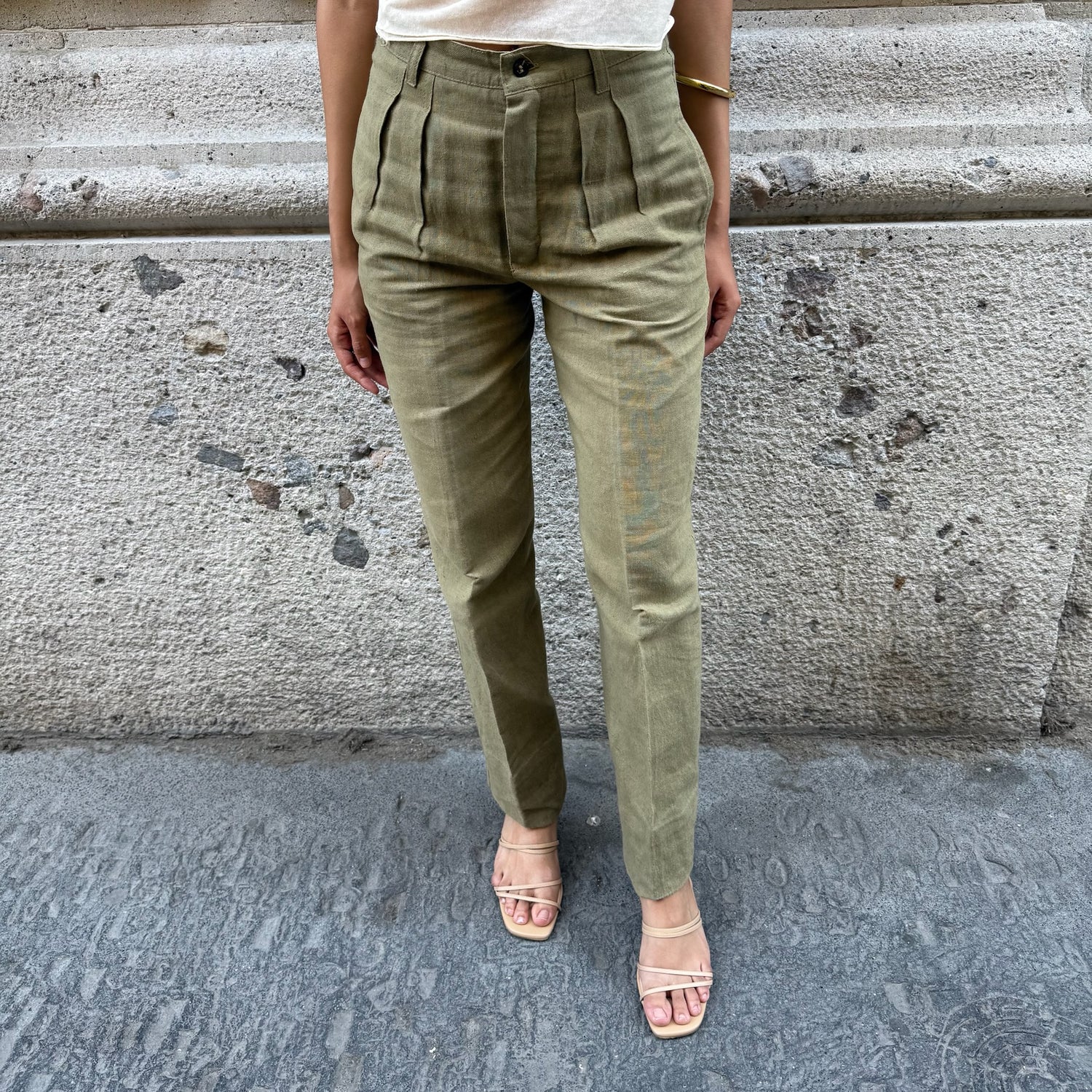 Front view of vintage olive green high-waisted tailored pants with front pleats and straight-leg silhouette.