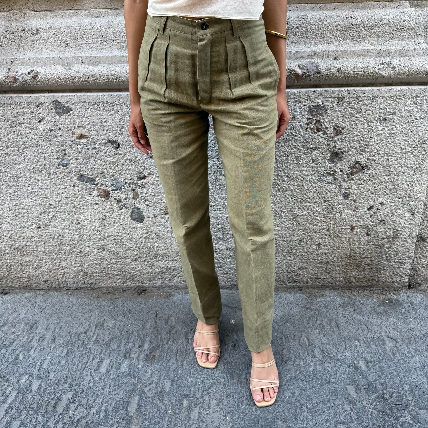 Front view of vintage olive green high-waisted tailored pants with front pleats and straight-leg silhouette.