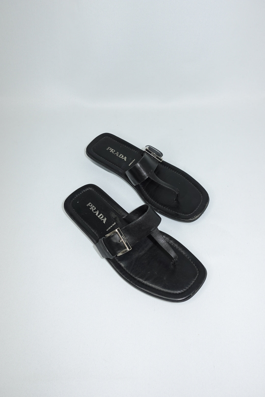 Vintage Prada black leather sandals side view showing sleek silhouette and silver buckle