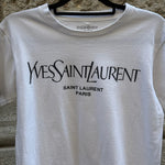 Close-up of the Yves Saint Laurent Paris logo printed on a white cotton T-shirt, highlighting the iconic designer branding and premium craftsmanship.